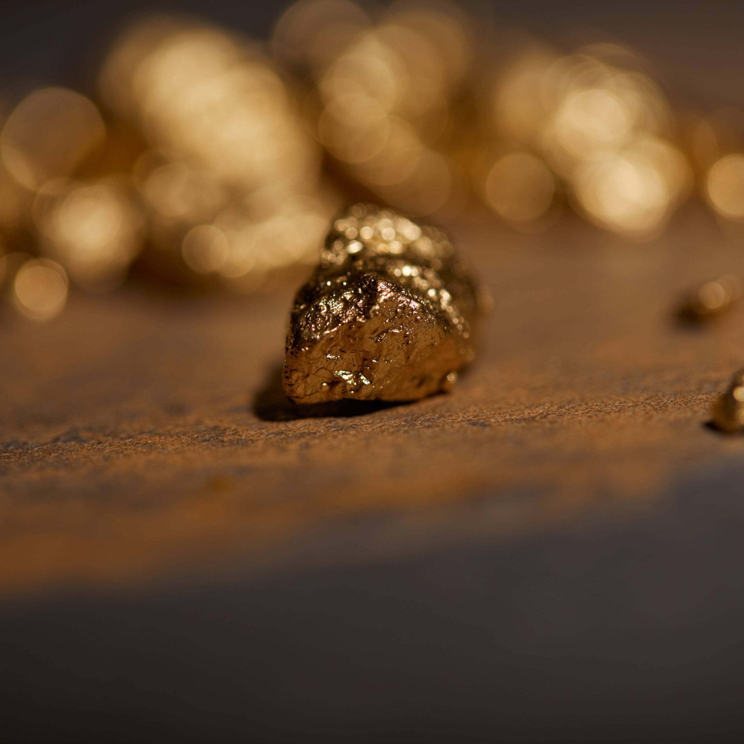 selective-focus-of-golden-stones-on-grey-and-brown-2024-11-08-10-08-11-utc